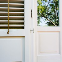 Particolare infisso e persiana in legno laccato bianco.