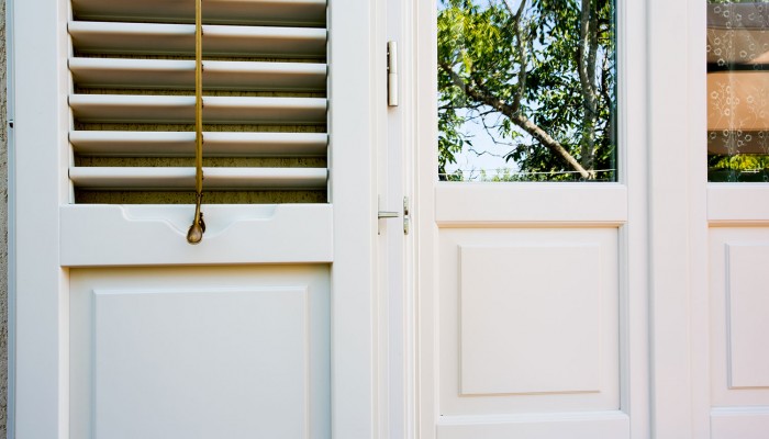Particolare infisso e persiana in legno laccato bianco. Particolare infisso e persiana in legno laccato bianco.